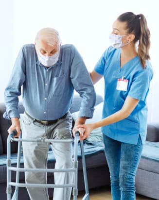 nurse assisting elderly man in walking