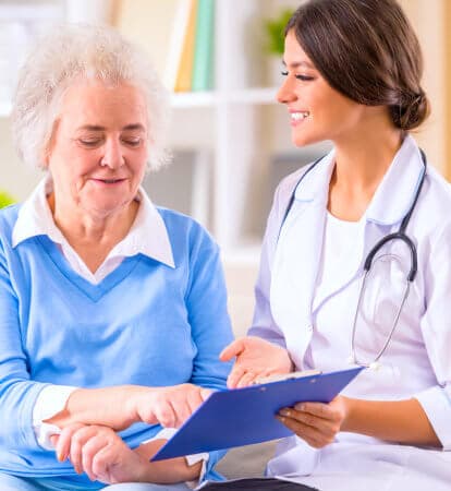 health professional presenting something to elderly woman